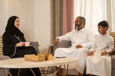 Saudi Family Talking in Living Room Wearing Traditional Dress