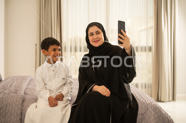 Saudi Mother and Son Taking Selfie in Bedroom