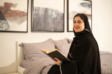 Saudi Woman in Abaya Reading Book in Bedroom