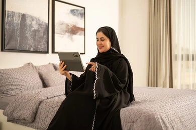 امرأة سعودية تستخدم الجهاز اللوحي في غرفة النوم