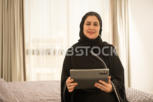 Saudi Woman with Tablet in Abaya Indoor