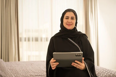Saudi Woman with Tablet in Abaya Indoor
