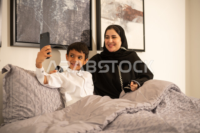 Saudi Mother and Son Taking Selfie in Bedroom
