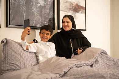 أم سعودية وابنها يلتقطان صورة سيلفي في غرفة النوم