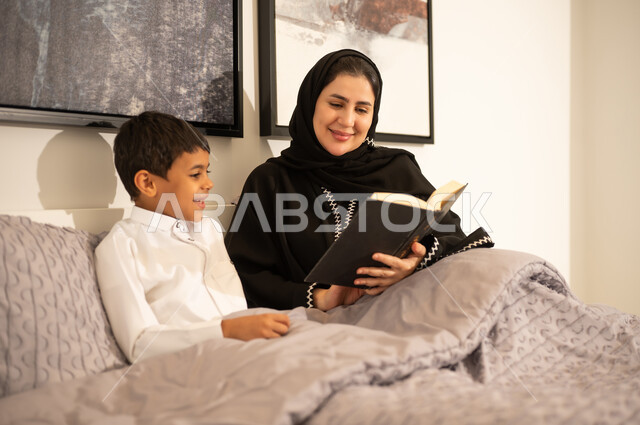 Saudi Mother Reading Book to Her Son in Bedroom Bed
