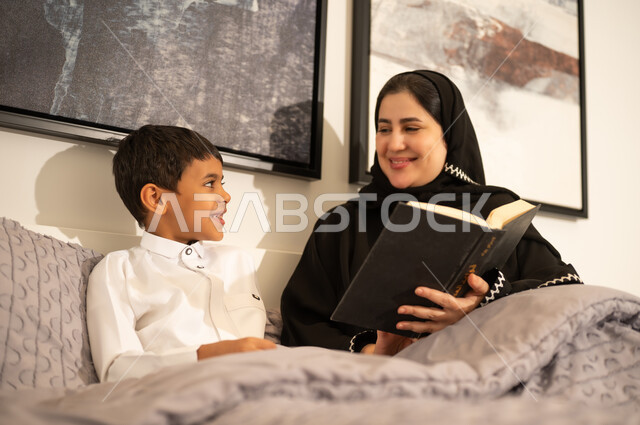Saudi Mother Reading Book to Son in Bedroom