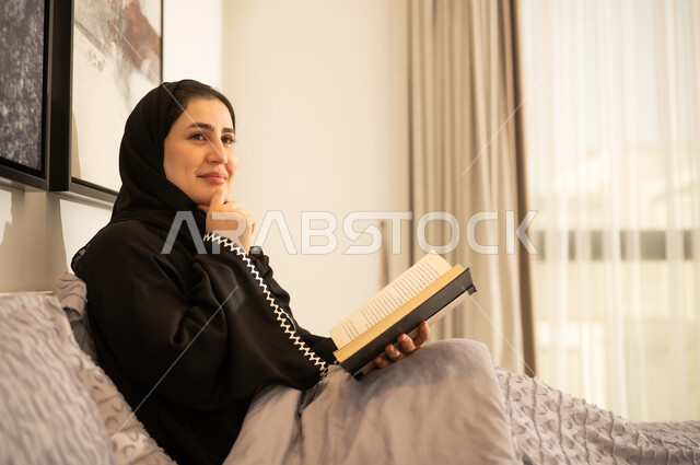 امرأة سعودية تقرأ كتاباً في السرير
