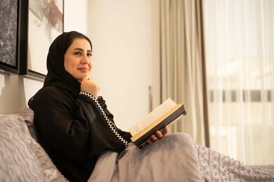 امرأة سعودية تقرأ كتاباً في السرير