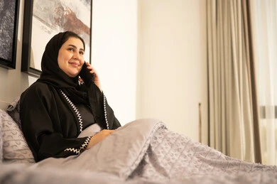 Saudi Woman in Abaya Talking on Phone in Bed