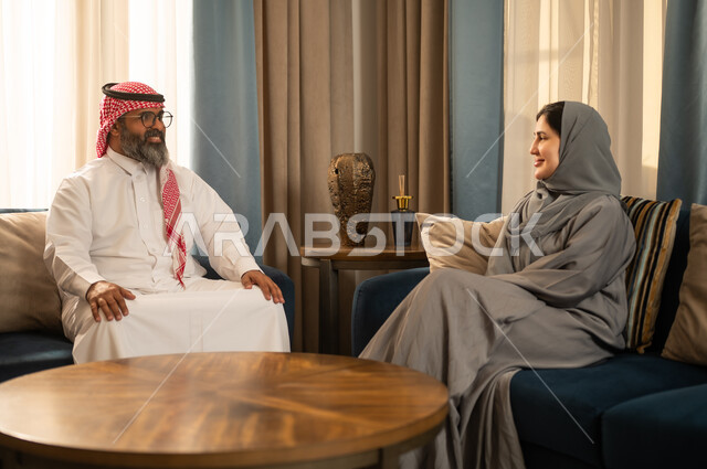 رجل وامرأة سعوديان يتحدثان في غرفة معيشة
