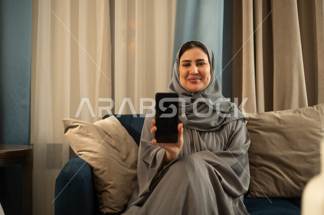 Saudi Woman Holding Smartphone in Living Room