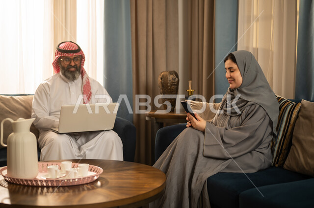 Saudi Man and Woman Using Technology at Home