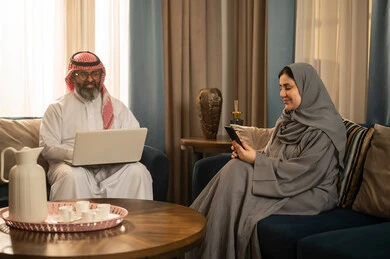 رجل وامرأة من السعودية يستخدمون التقنية في المنزل