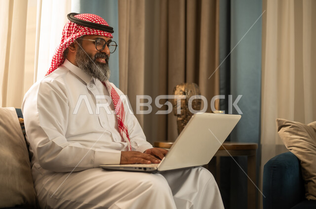 Saudi Man Using Laptop in Traditional Thobe