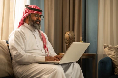 Saudi Man Using Laptop in Traditional Thobe Saudi Man Using Laptop in Traditional Thobe