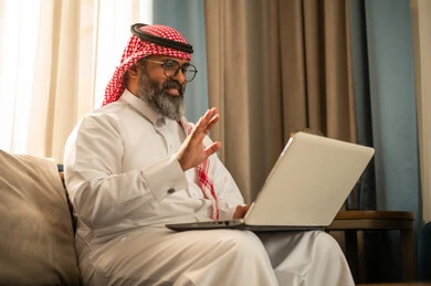 رجل سعودي يستخدم اللابتوب لمكالمة فيديو في المنزل