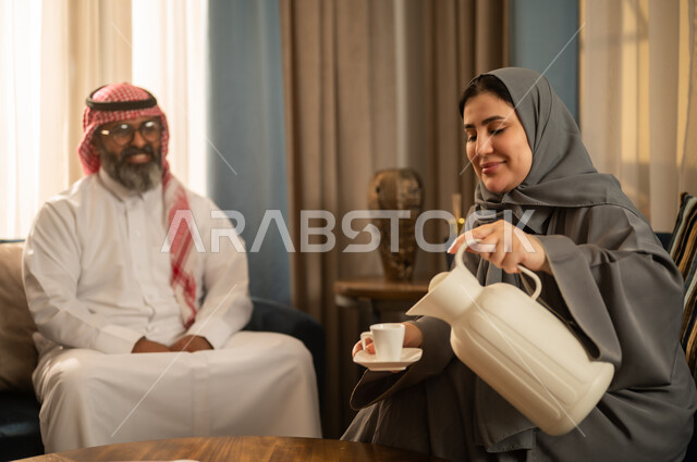 امرأة سعودية تصب القهوة لرجل باللباس التقليدي
