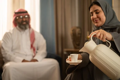 امرأة سعودية تسكب القهوة العربية في مجلس تقليدي