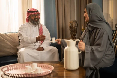 رجل وامرأة سعوديان يتناولان القهوة العربية في المنزل