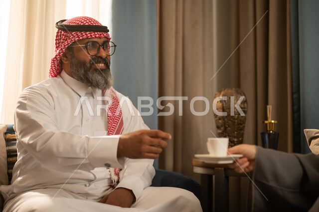 رجل سعودي بالزي التقليدي يتناول القهوة العربية