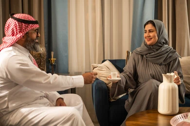 رجل وامرأة سعوديان يتناولان القهوة العربية في المنزل
