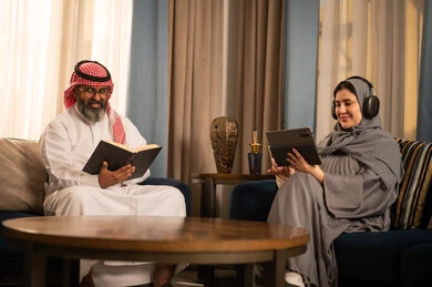 زوجان سعوديان يقرآن ويستخدمان جهاز لوحي في المنزل