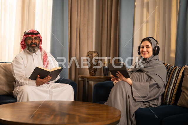 رجل وامرأة من السعودية مع كتاب وجهاز لوحي