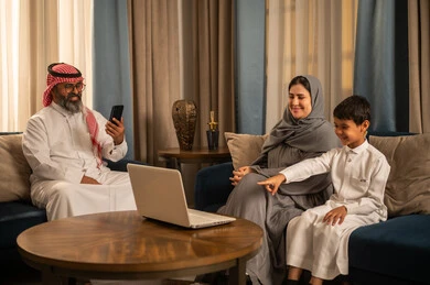 عائلة سعودية تستخدم الكمبيوتر المحمول والهاتف في المنزل