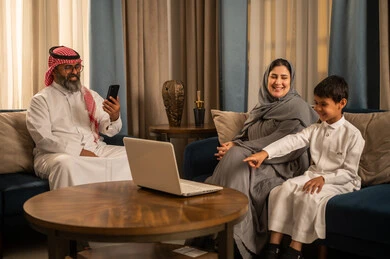 عائلة سعودية تستخدم الكمبيوتر المحمول في غرفة المعيشة