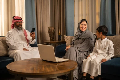 Saudi Family with Laptop and Smartphone in Living Room