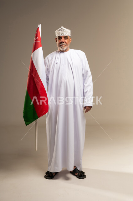 رجل عماني مسن يحمل علم سلطنة عمان