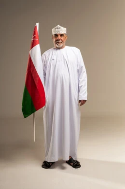 رجل عماني مسن يحمل علم سلطنة عمان