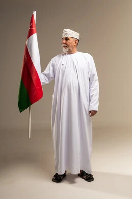 رجل عماني مسن يحمل علم سلطنة عمان