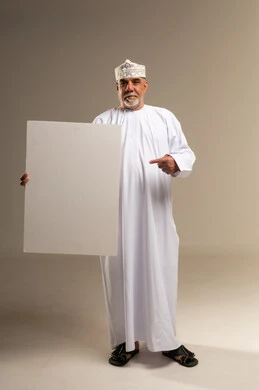 رجل عماني بالزي التقليدي يحمل لوحة بيضاء فارغة