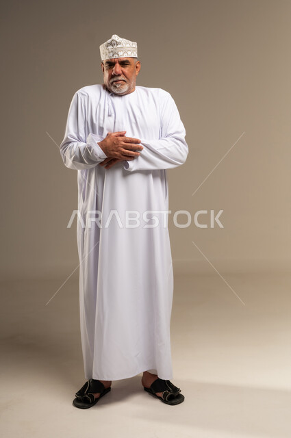 Elderly Omani Man in Traditional Dress Standing in Studio