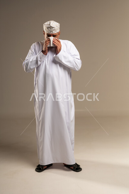 Omani Man Sneezing with Tissue in Studio