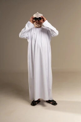 Elderly Omani Man Looking Through Binoculars in Studio