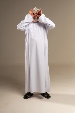 رجل عماني بالزي التقليدي يقوم بحركة فكاهية