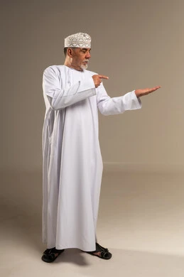 رجل عُماني مسن بالزي التقليدي يشير بيده
