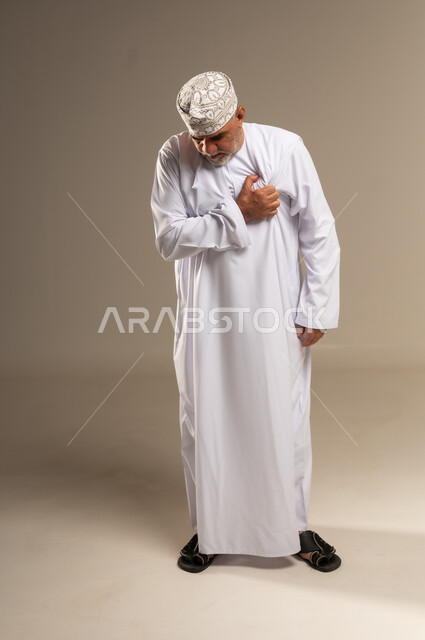 رجل عماني بالزي التقليدي يشعر بألم في الصدر