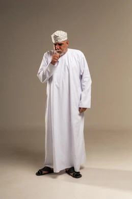 رجل عُماني مسن يسعل بالزي التقليدي