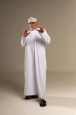 رجل عماني بالزي التقليدي مع إيماءات اليد في الاستوديو