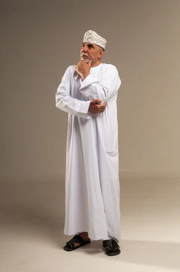 رجل عماني مسن يفكر بالزي العماني التقليدي