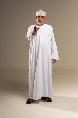 Senior Omani Man Pointing in Traditional Attire