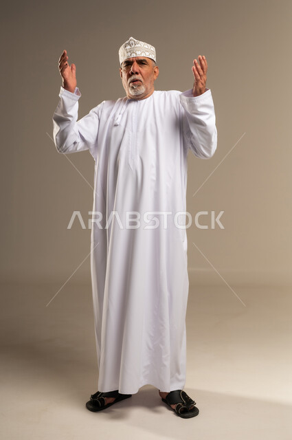 Elderly Omani Man Praying in Traditional Dress