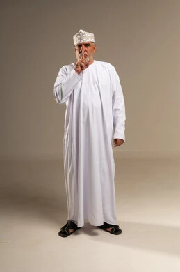 Senior Omani Man in Traditional Dress Making Silence Gesture