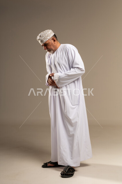 Omani Man in Traditional White Dishdasha Praying