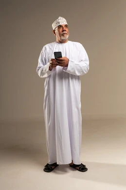 Omani Senior Man Holding Smartphone in Studio