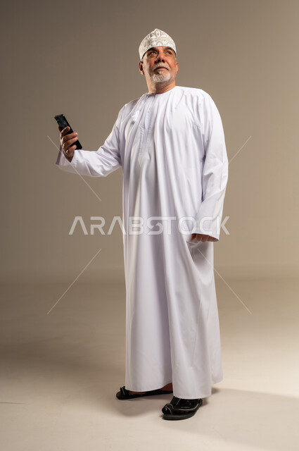 Omani Senior Man in Traditional Dress with Smartphone