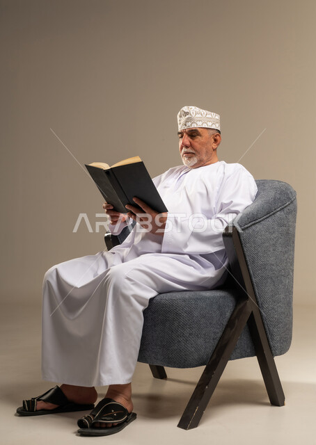 Elderly Omani Man Reading a Book in Studio